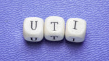 This image contains three dice that spell out UTI