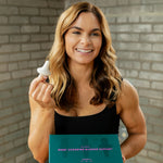 Portrait of Caroline Packard holding the Uresta Starter Kit box in one hand and the Uresta in the other.